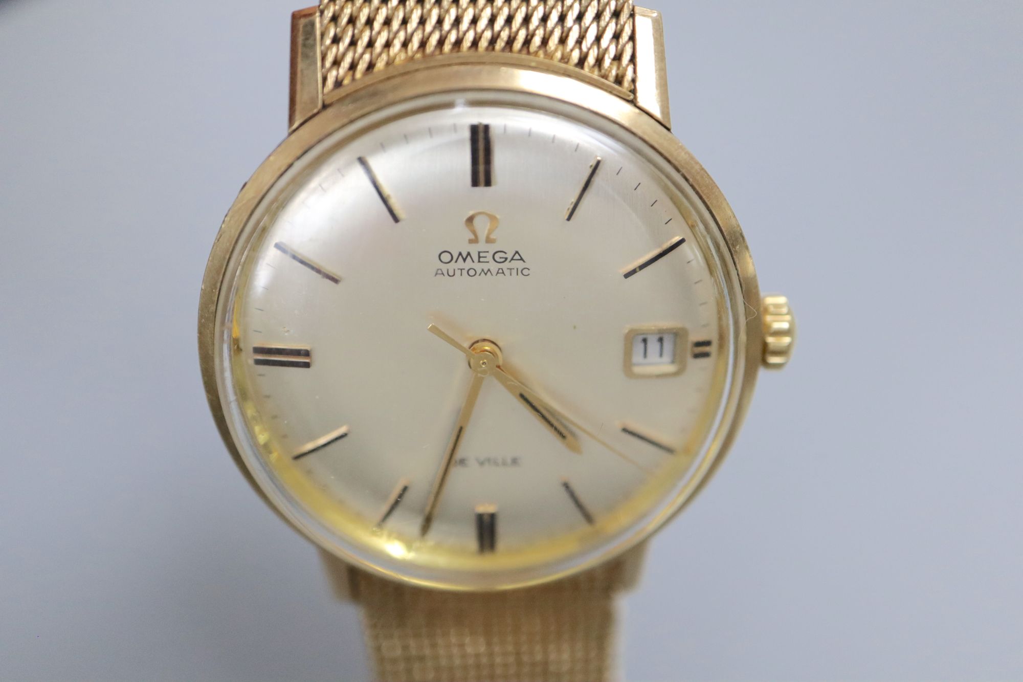 A gentlemans early 1970s 9ct gold Omega De Ville automatic wrist watch, on integral Omega 9ct gold bracelet,
